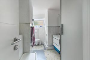 a white bathroom with a toilet and a sink at eva Ferienwohnung in Engen +14 photos