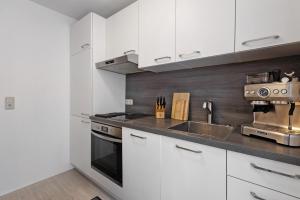 a kitchen with white cabinets and a sink at eva Ferienwohnung in Engen