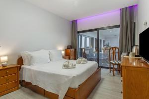 a hotel room with a bed and a balcony at Paraiso Madeira - Suites in Gaula +38 photos