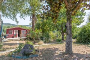 a red house in the middle of a garden at Peaceful Countryside Getaway in Parbayse