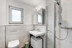 a white bathroom with a sink and a shower at Ferienwohnung Blumenau in Schmallenberg +19 photos