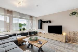 a living room with a couch and a flat screen tv at Ferienwohnung Blumenau in Schmallenberg