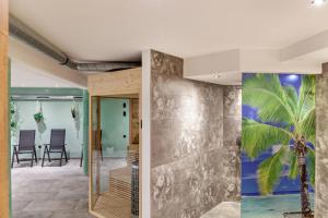 an open lobby with a palm tree mural on the wall at Chalet Aus Holz in Garmisch-Partenkirchen +24 photos