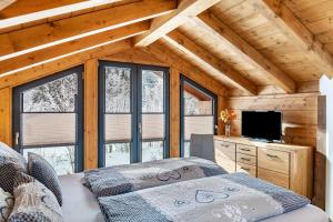 a room with two beds and a television in a cabin at Chalet Aus Holz in Garmisch-Partenkirchen