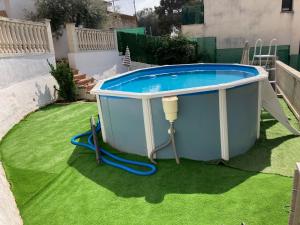 a large hot tub in a yard with a hose at Lola's Beach House in Calafell