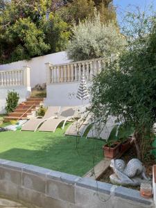 a garden with a lawn with two statues on it at Lola's Beach House in Calafell