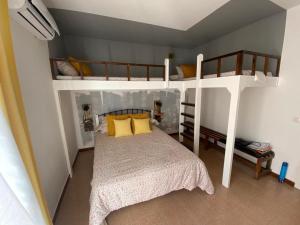 a bedroom with two bunk beds with yellow pillows at Lola's Beach House in Calafell +25 photos
