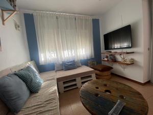 a living room with a couch and a flat screen tv at Lola's Beach House in Calafell