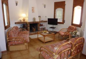 a living room with couches and a tv and a fireplace at El Castillito in Begur