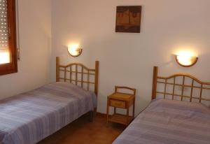 a bedroom with two beds and a table and lights at El Castillito in Begur