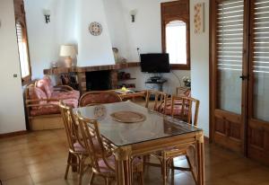 a dining room with a table and chairs and a television at El Castillito in Begur