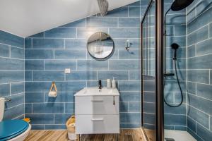a blue tiled bathroom with a sink and a shower at Les gîtes de virginie in Bourg-sur-Gironde +15 photos