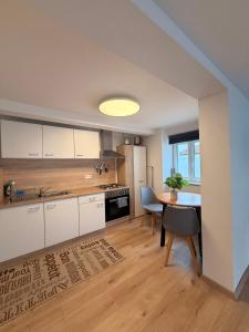 a kitchen with white cabinets and a table with a potted plant at Fewo im schönen Allensbach in Allensbach