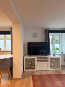 a living room with a flat screen tv on a white cabinet at Fewo im schönen Allensbach in Allensbach