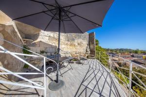 a patio with an umbrella and a table and chairs at Les gîtes de virginie in Bourg-sur-Gironde