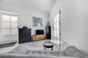 a living room with a couch and a tv at Les gîtes de virginie in Bourg-sur-Gironde