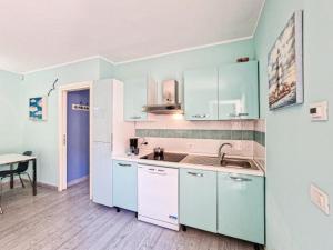 a kitchen with blue and white cabinets and a table at Villa Galatea Stella Marina in Capoliveri +26 photos