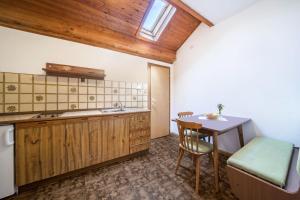 a kitchen with a table and a chair and a sink at Apartment Tschigat Leilichhof in Lana
