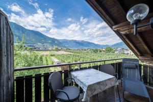 a balcony with a table and chairs and mountains at Apartment Tschigat Leilichhof in Lana
