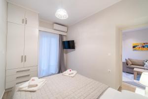 a white bedroom with a bed and a couch at Seawind Gouvia in Corfu