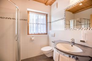 a bathroom with a sink and a toilet and a shower at App Lisüra Boè in Corvara in Badia +18 photos