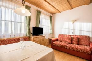 a living room with a table and a couch at App Lisüra Boè in Corvara in Badia