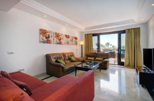 a living room with two couches and a television at Exclusive frontline beach penthouse in Estepona