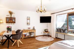 a living room with a television and a table and a chair at Aschaubichl - Wohnung Bergaurikel in Grainau
