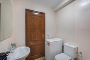 a bathroom with a toilet and a sink and a wooden door at Las Flores 1D in Costa de Adeje +12 photos