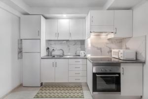 a white kitchen with a sink and a microwave at Las Flores 1D in Costa de Adeje