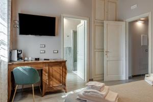 a room with a desk and a television on a wall at Il Borghetto Bed and Breakfast in Borgo San Lorenzo