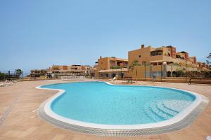 a swimming pool in a resort with buildings in the background at Casa Carlos in Corralejo