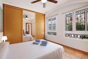 a bedroom with a bed with two blue towels on it at Casa Carlos in Corralejo +26 photos