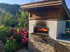 a stone pizza oven with a fire in it at Trenklehof in Simonswald