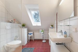 a bathroom with a sink and a toilet and a window at Ferienwohnung Offenbüttel in Oldenbüttel +35 photos