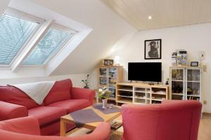 a living room with a red couch and a tv at Ferienwohnung Offenbüttel in Oldenbüttel
