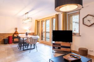 a living room with a television and a table at Lodge Alouette in Champagny-en-Vanoise