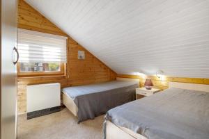 a attic bedroom with two beds and a window at Haus Wildgans in Lychen