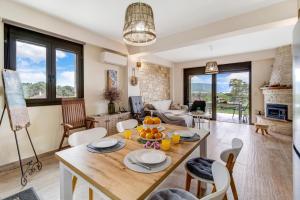 a kitchen and living room with a table and chairs at Lefkada view villa Vasiliki 1 in Peratiá