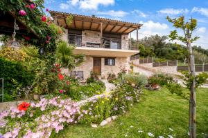 a house with flowers in front of it at Lefkada view villa Vasiliki 1 in Peratiá