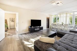 a living room with a couch and a flat screen tv at Haus am See in Quickborn