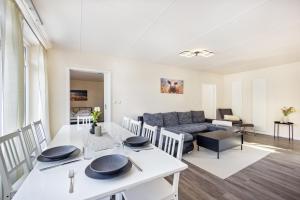 a living room with a white table and a couch at Haus am See in Quickborn