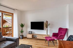 a living room with a tv on a white wall at Alpblick Apartment Alpspitze in Garmisch-Partenkirchen