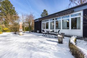 a house in the snow with a table and chairs at Haus am See in Quickborn