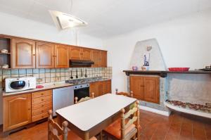 a kitchen with wooden cabinets and a table and a sink at Casa Alan in Montemezzo +15 photos