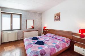a bedroom with a bed with a pink and blue comforter at Casa Alan in Montemezzo