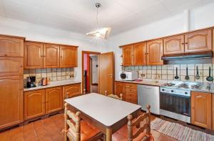 a kitchen with wooden cabinets and a table at Casa Alan in Montemezzo