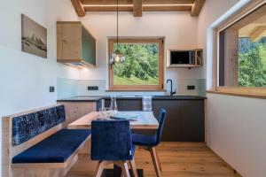 a kitchen with a table and chairs and a window at Chalet Kasch Apartment Berg in Völs am Schlern