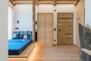 a bedroom with a bed and wooden doors at Chalet Kasch Apartment Berg in Völs am Schlern