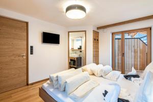 a living room with a white couch and a television at Planerhof Apartment Alpenrose in Funes